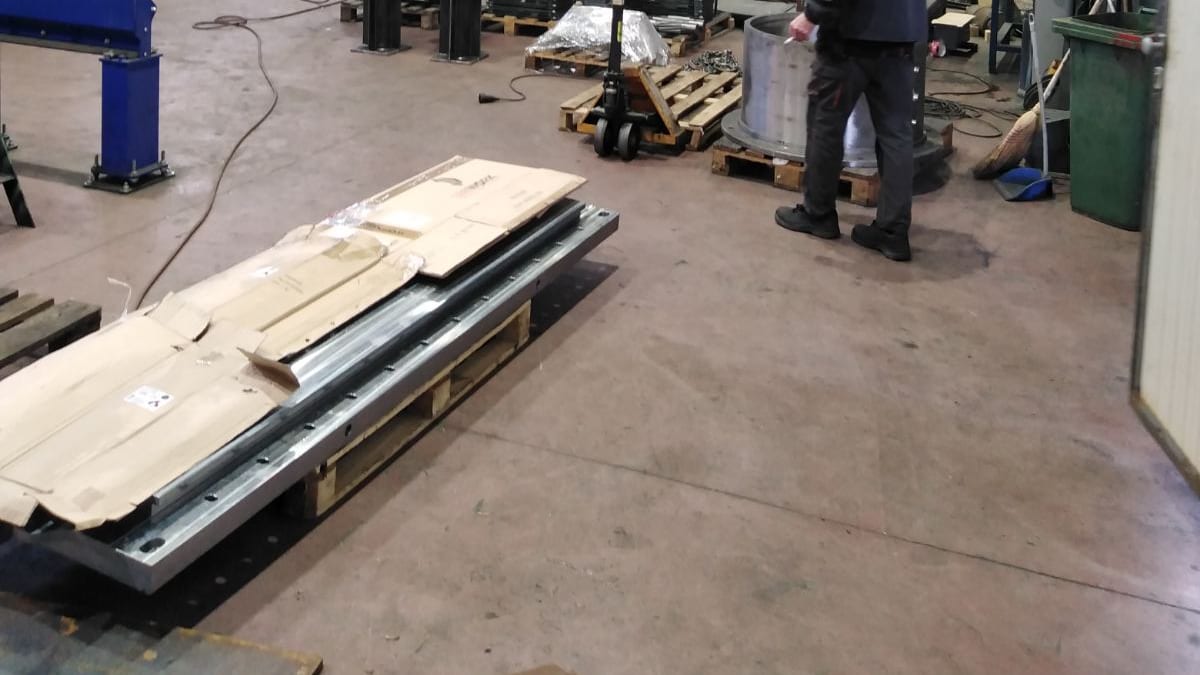 Assembly hall with a yellow overhead crane, hook and prepared steel sections